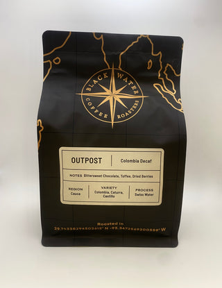 Black coffee bag with gold accents featuring 'Black Water Coffee Roasters' on a white background with a Outpost (Colombia Decaf) label